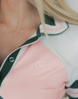 A woman wearing a pink and green Betty Polo shirt with chevron print and a preppy collar.