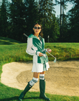 A person wearing a green Elle Rain Jacket with a matching green boots.