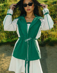 A person wearing a green Elle Rain Jacket.