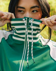 A person wearing a green Elle Rain Jacket.