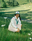 Model wearing a green and white cap with 'Golfing Optional' text.