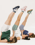 Three models laying on the floor all wearing biddy shorties and erin dresses.