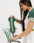 Woman in sports uniform interacting with a golf bag on a white background