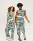 Two models wearing a pair of green checkered pants with a relaxed fit and pockets, worn with a matching checkered top and sneakers.