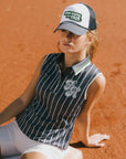A woman wearing a sleeveless navy blue and white striped Moore Polo golf top.