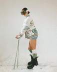 Person in winter gear with skis and poles on a white background