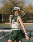 A woman wearing a white and green visor with a 'FA' logo on the front.
