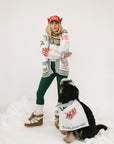 Person wearing a sweater with colorful text and designs on a white background