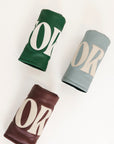 Three Lynn Fairway Covers in green, smoke blue, and merlot with 'FORE' printed on them against a white background.