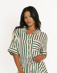 Woman wearing a green and white striped dress on a white background