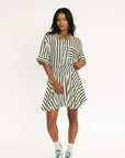 Woman wearing a green and white striped top and skirt on a white background