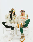 Two people sitting on chairs wearing stylish outfits with accessories.