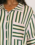 Close-up of a person wearing a striped shirt with green, yellow, and beige colors.