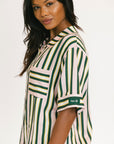 Woman wearing a striped shirt with a visible brand logo on a white background