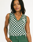 Woman wearing a green and white checkered sleeveless top with a logo on a white background