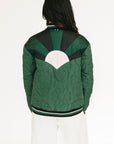 Green quilted jacket with a unique back design on a white background