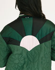 Green quilted jacket with black accents on a plain background