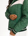 Green and white quilted jacket with a person wearing it on a white background
