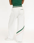 Person wearing white pants with green stripes and a green top on a white background