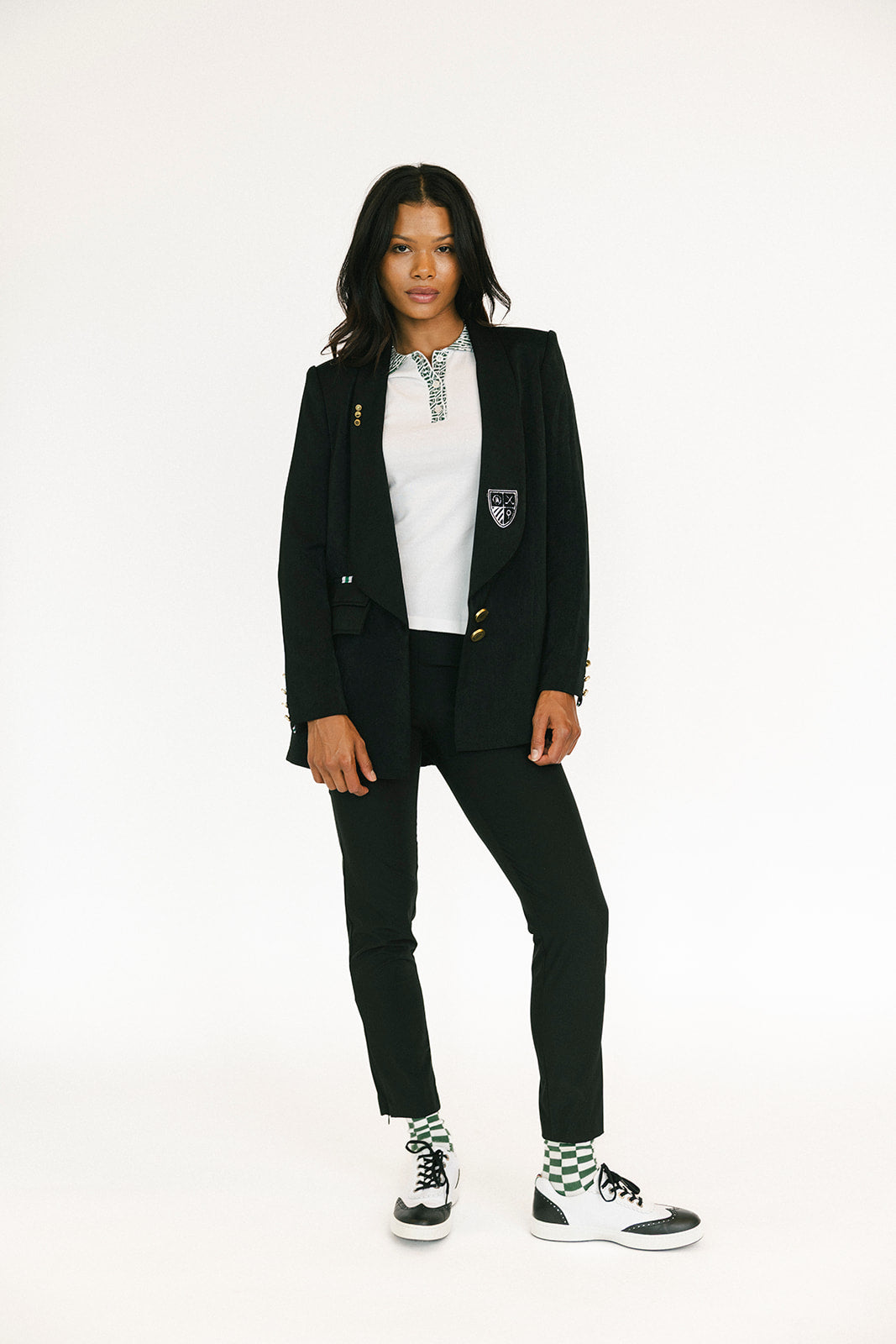 Person wearing a black blazer and pants with a white shirt on a white background
