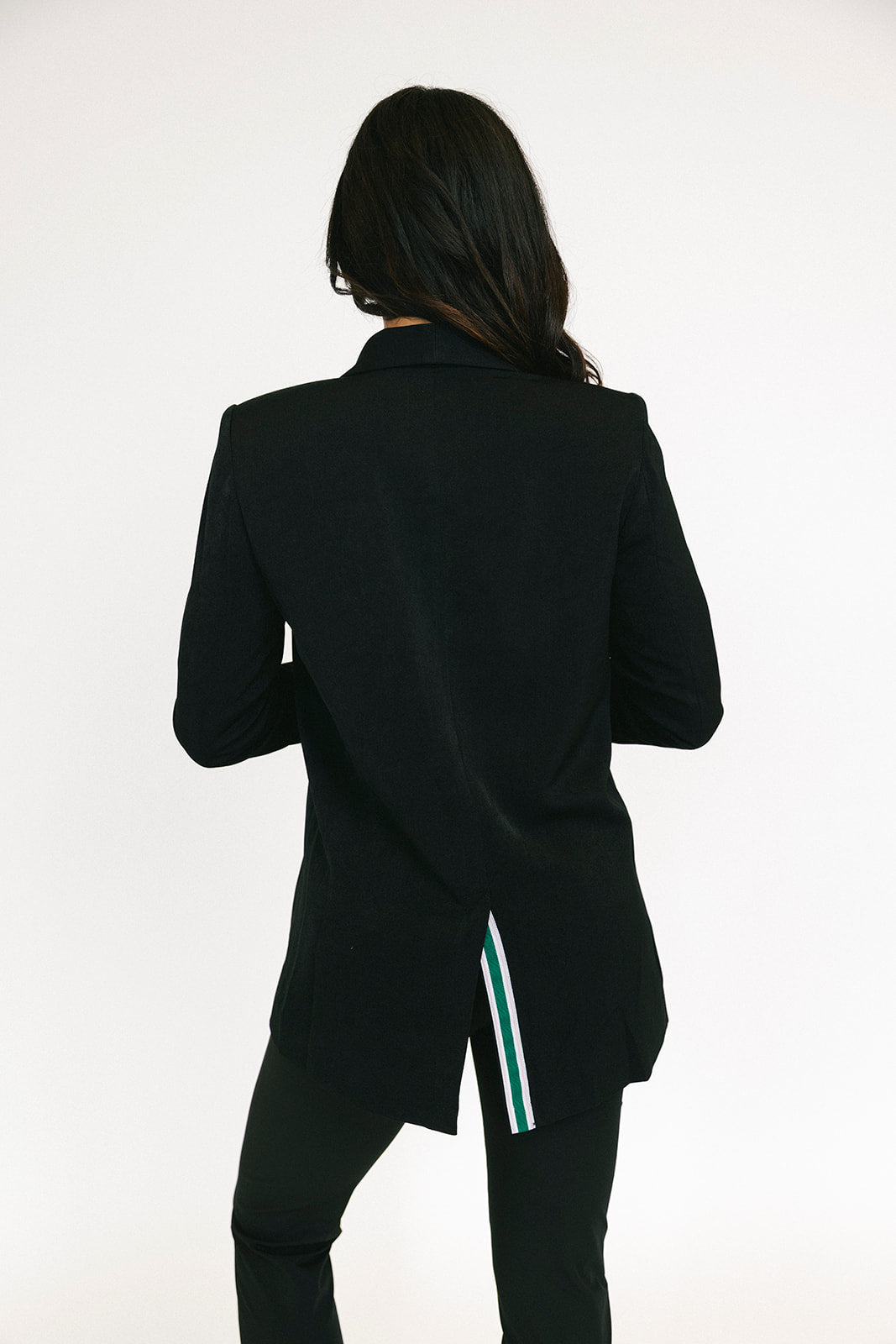 Person wearing a black blazer with a white background