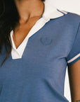 Blue and white polo shirt with a logo on a blurred background