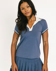 Woman wearing a blue and white outfit with a pleated skirt on a white background