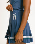 Blue golf skirt with pockets and golf tees on a white background
