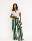 Person wearing green and white striped pants with a white top on a white background