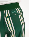Person wearing green and white striped pants with a white top on a white background
