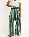 Person wearing green and white striped pants with a white top on a white background