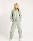 Person wearing a light green tracksuit on a white background