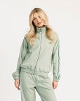 Woman wearing a light green tracksuit on a white background
