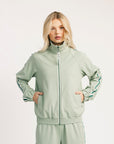 Woman wearing a light green tracksuit on a white background