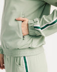 Light green tracksuit with white and green stripes on a plain background
