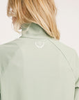 Light green jacket with a brand logo on a plain background