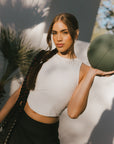 Woman holding a basketball with palm trees in the background