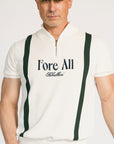 A man wearing a beige zip sweater with vertical green stripes and the text 'Fore All x Khalhon' on the chest, paired with dark green shorts.