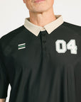Man wearing a black and beige polo shirt with '04' on a white background
