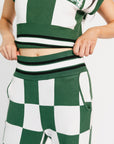 Green and white checkered outfit with a cropped top and pants on a plain background