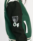 Green and black varsity jacket with a logo and number on a white background