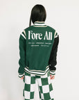 Person wearing a green and black varsity jacket with 'Fore All' text on the back, standing against a white background.