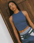 A model wearing the Fore All Lillee Tank in Indigo paired with indigo pants.