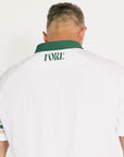 Person wearing a white polo shirt with 'FORE' printed on the back, standing against a plain background.