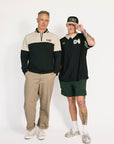Two people standing side by side wearing casual clothing on a white background