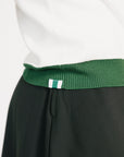 Woman wearing a green and white sweater with 'FORE' text on a plain background