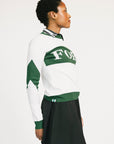 Woman wearing a green and white sweater with 'FORE' text on a plain background