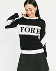 Person wearing a black and white sweater with 'FORE' printed on it against a plain background