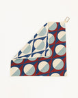 Golf towel with geometric pattern hanging on a white background