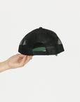 Black and green cap with 'GET OFF MY BACK' text held by a hand on a white background.